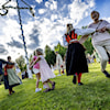 folk som dansar runt midsommarstången.